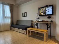 a room with a couch and a table and a tv at NK Hostel in Taipei