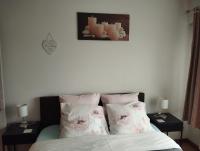 a bedroom with a bed with pillows and two tables at Logies Lily in Oudenburg
