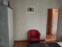 a red chair sitting in a room with a wall at Logies Lily in Oudenburg