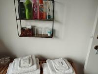 a bathroom with two white towels on a shelf at Logies Lily in Oudenburg
