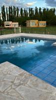 Una gran piscina con una casa al fondo. en Rio los Patos, en Barreal
