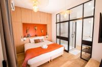 a bedroom with a bed with an orange wall at LOLA Boutique Hôtel - Bordeaux Centre in Bordeaux