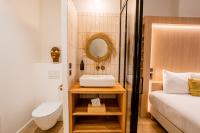 a bathroom with a sink and a toilet next to a bed at LOLA Boutique Hôtel - Bordeaux Centre in Bordeaux