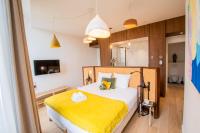 a bedroom with a bed with a yellow blanket at LOLA Boutique Hôtel - Bordeaux Centre in Bordeaux