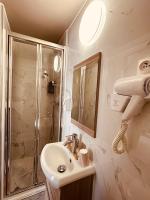 a bathroom with a sink and a shower at Pavillon Opéra Lafayette in Paris