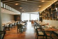 a dining room with tables and chairs in a restaurant at Gokulam Grand Trivandrum in Trivandrum