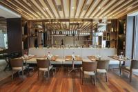 a restaurant with wooden ceilings and tables and chairs at Gokulam Grand Trivandrum in Trivandrum