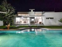 Una gran piscina frente a una casa por la noche. en RESIDENCIA EL ENCINO, en Cuatrociénegas de Carranza