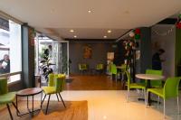 Un restaurante con sillas y mesas verdes en una habitación. en SC HOTEL, en Xalapa