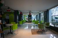 un comedor con sillas y mesas verdes en un restaurante en SC HOTEL, en Xalapa