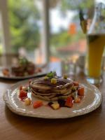 阿杭格默Ebony Boutique Villa的桌子上放着一盘煎饼和水果