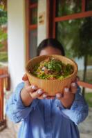 eine Person, die eine Schüssel Essen in ihren Händen hält in der Unterkunft Aurea Bacalar in Bacalar