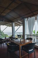 een eetkamer met een houten tafel en stoelen bij Raposo Resorts in Vagator