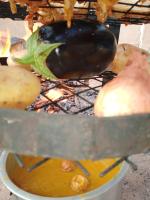 Una berenjena y patatas se cocinan en una parrilla en Petra Musa Rural House, en Wadi Musa