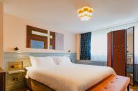 a bedroom with a large white bed and a window at Hotel Mercier in Amsterdam