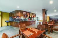 a restaurant with wooden tables and chairs and a bar at Elite Suites Patong in Patong Beach