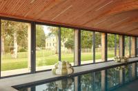 a screened in porch with windows and a wooden ceiling at DOMAINE LE MEZO in Ploeren