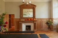 a living room with a fireplace with a grandfather clock at DOMAINE LE MEZO in Ploeren