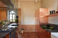 a kitchen with wooden cabinets and a stove top oven at DOMAINE LE MEZO in Ploeren