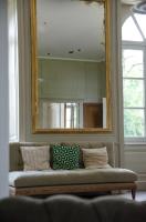 a mirror above a couch in a living room at DOMAINE LE MEZO in Ploeren