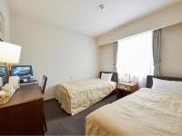 Una habitación de hotel con dos camas y un televisor. en Ichihara Marine Hotel, en Ichihara