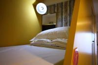 a bedroom with a bed and a clock on the wall at Hive Bed and Backpacker蜂巢膠囊旅店 in Hualien City