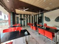 Sītāpur MūāfiHotel Ramghat inn -In front of Mandakini River的一间设有红色椅子的用餐室和一间酒吧