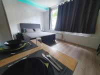 Un dormitorio con una cama y una mesa y una ventana. en Le Cosy - Queen-size, full équipé, wifi, parking, en Namur