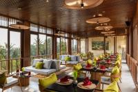 a lobby of a resort with tables and chairs at Inara Alas Harum in Ubud