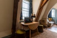 a living room with a table and two windows at Hotel Mercier in Amsterdam