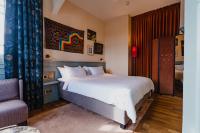 a bedroom with a large white bed and a chair at Hotel Mercier in Amsterdam