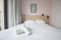 a white bed with two white towels on it at FINESTATE Coliving Champs-Elysées in Paris