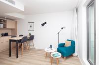 a living room with a blue chair and a table at FINESTATE Coliving Champs-Elysées in Paris