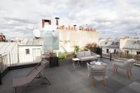 a patio with chairs and tables on a roof at FINESTATE Coliving Champs-Elysées in Paris