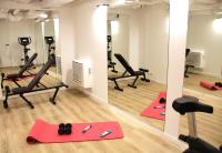 a gym with red pilates equipment and mirrors at FINESTATE Coliving Champs-Elysées in Paris