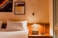 a bedroom with a bed and a table with a clock at Hotel Mercier in Amsterdam