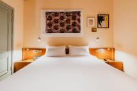 a bedroom with a large bed with white pillows at Hotel Mercier in Amsterdam