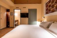 a bedroom with a large white bed and a television at Hotel Mercier in Amsterdam