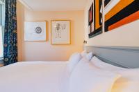 a bedroom with a bed and some paintings on the wall at Hotel Mercier in Amsterdam
