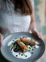 Una mujer sosteniendo un plato de comida con zanahorias encima. en Hotel & Restaurant Casolare Le Terre Rosse, en San Gimignano