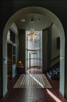 a hallway with a chandelier and a tile floor at Hotel Mercier in Amsterdam