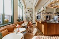a restaurant with tables and chairs and a bar at Hotel Mercier in Amsterdam
