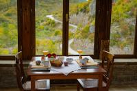 基波伊Kipi Mountain Resort的一张木桌，上面放着两杯葡萄酒，视野开阔。