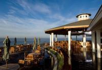 ein Restaurant mit Tischen und Stühlen und dem Meer in der Unterkunft 1314 Pelican Watch - Seabrook Island - Beachfront 5 Star Condo - Fido Friendly in Seabrook Island