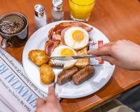 a plate of breakfast food with eggs bacon and sausage at Great Southern Hotel Brisbane in Brisbane