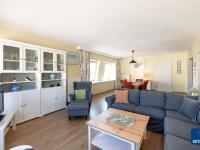 a living room with a blue couch and a table at Lilyta B403 4A apartment in De Haan near the sea in De Haan