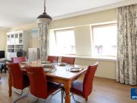 a dining room with a table and chairs and two windows at Lilyta B403 4A apartment in De Haan near the sea in De Haan