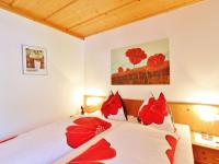 a bedroom with two beds with red pillows at Apartment in Bramberg am Wildkogel with balcony in Bramberg am Wildkogel