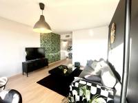 sala de estar con sofá y TV de pantalla plana en Charlie et la Chocolaterie- Parking- Clim- CentreVille, en Montauban