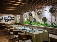 a restaurant with tables and chairs and mirrors on the wall at Swissotel Buyuk Efes Izmir in Izmir